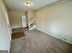 Spacious living room featuring neutral carpeting, baseboard trim, and a staircase leading to the upper level at 1908 S Columbia Pl, Decatur, GA 30032