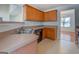 Well-lit kitchen with wood cabinets, a double sink, and a view of the dining room beyond at 6380 Winston Trce, Mcdonough, GA 30252