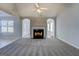 Open-concept living room with a fireplace and neutral carpet, creating a cozy and inviting space at 6380 Winston Trce, Mcdonough, GA 30252