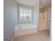 Bright bathroom featuring a shower and tub with window at 5120 Redcoat Ln, Mcdonough, GA 30252
