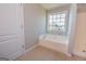 Bright bathroom featuring a tiled floor and tub with window at 5120 Redcoat Ln, Mcdonough, GA 30252