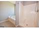 Bright bathroom featuring a shower and tub with tiled floor at 5120 Redcoat Ln, Mcdonough, GA 30252