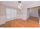 Classic dining room with wainscoting, hardwood floors, a modern chandelier, and bright window at 5120 Redcoat Ln, Mcdonough, GA 30252