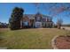Charming two-story brick home with a well-manicured lawn and mature trees on a sunny day at 5120 Redcoat Ln, Mcdonough, GA 30252