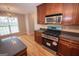 Kitchen with stainless steel range, dark countertops and view of chandelier lit dining area at 5120 Redcoat Ln, Mcdonough, GA 30252