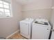A laundry room with a window, shelving, and white Samsung washer and dryer units at 5120 Redcoat Ln, Mcdonough, GA 30252