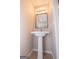 A well-lit powder room featuring a modern mirror, wall lighting, and a pedestal sink at 5120 Redcoat Ln, Mcdonough, GA 30252