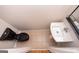 A top-down view of a powder room featuring a black toilet and a modern white pedestal sink at 5120 Redcoat Ln, Mcdonough, GA 30252