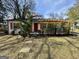 Cozy bungalow with a red door and wood-accented trim, complemented by mature landscaping at 230 Argus Cir, Atlanta, GA 30331