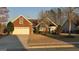 Charming brick home featuring an attached two-car garage and a blossoming tree in the landscaped front yard at 1006 Harbor View Ln, Mcdonough, GA 30252