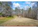 Expansive backyard featuring a flat grassy area surrounded by mature trees and a wooded landscape at 1191 Rawlings Dr, Rutledge, GA 30663