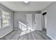 Neutral bedroom features gray plank floors and view to the front yard at 2773 Marcia Dr, Lawrenceville, GA 30044