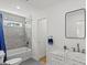 Bathroom featuring a tiled tub, marble counter, and modern fixtures at 1077 Peeples Sw St, Atlanta, GA 30310