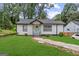 Charming single-story home with freshly cut lawn and walkway leading to a delightful turquoise front door at 1077 Peeples Sw St, Atlanta, GA 30310