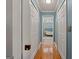 Hallway with wooden floors and blue walls leading to a bright bathroom at 707 Orleans Trce, Peachtree City, GA 30269