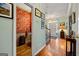 Hallway featuring hardwood floors leading to a powder room with unique patterned wallpaper at 707 Orleans Trce, Peachtree City, GA 30269