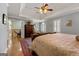 Main bedroom with decorative rug, wood floors, tray ceiling, and light filled window at 707 Orleans Trce, Peachtree City, GA 30269