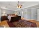 Main bedroom with tray ceiling, decorative rug, wood floors, and neutral decor at 707 Orleans Trce, Peachtree City, GA 30269