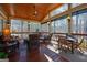 Inviting screened porch featuring a wood ceiling, ceiling fan, and a comfortable seating and dining area at 707 Orleans Trce, Peachtree City, GA 30269