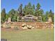 Stone community entrance sign, lush landscaping, and mature trees create a welcoming entrance at 135 Red Maple Dr, Peachtree City, GA 30269