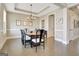 Spacious dining room with a coffered ceiling, hardwood floors, and a large dining table at 135 Red Maple Dr, Peachtree City, GA 30269