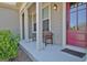 Welcoming front porch boasting a red door, white columns, a cozy bench, and lovely details at 135 Red Maple Dr, Peachtree City, GA 30269