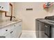 Functional laundry room with granite countertop, sink, and modern washer/dryer at 135 Red Maple Dr, Peachtree City, GA 30269