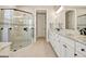 A well-lit bathroom with a glass shower, granite counters, and white cabinets at 135 Red Maple Dr, Peachtree City, GA 30269