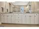 Bathroom with granite countertops, white cabinets, double sinks, and framed mirror at 135 Red Maple Dr, Peachtree City, GA 30269