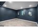 Finished basement area with gray tile flooring, navy blue walls, recessed lighting, and movie poster decorations at 157 Donovan Ave, Locust Grove, GA 30248
