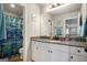 This bathroom has a large mirror, white vanity and a colorful shower curtain at 157 Donovan Ave, Locust Grove, GA 30248
