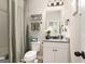 Well-lit bathroom features a single sink with grey counters, white cabinets, and a shower with patterned curtain at 157 Donovan Ave, Locust Grove, GA 30248
