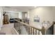 Upstairs hallway landing with black railing and view of a living space with couch, TV and toy storage at 157 Donovan Ave, Locust Grove, GA 30248