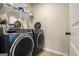 This laundry room has modern blue front load washer and dryer with a rack for storage at 157 Donovan Ave, Locust Grove, GA 30248