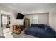 Upstairs living space with a large blue couch, mounted TV, toy storage, and large window at 157 Donovan Ave, Locust Grove, GA 30248