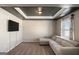 Cozy living room features a comfy sectional couch, a dark accent ceiling, and a mounted TV at 157 Donovan Ave, Locust Grove, GA 30248