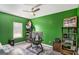 Home office design with green walls, ceiling fan, gray floors and a large window with blinds at 157 Donovan Ave, Locust Grove, GA 30248
