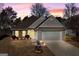 Charming single-story home featuring a manicured lawn, two-car garage, and inviting exterior lighting at 1160 Strath Clyde Way, Mcdonough, GA 30253