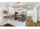 Bright kitchen with stainless steel appliances, stone counters, island sink and pendant lighting at 1160 Strath Clyde Way, Mcdonough, GA 30253