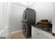 Laundry room with stackable washer and dryer, granite countertop, and tiled flooring at 1160 Strath Clyde Way, Mcdonough, GA 30253