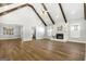 Open living room with wood floors, exposed beams and a fireplace with stone surround at 1160 Strath Clyde Way, Mcdonough, GA 30253