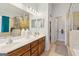 Bathroom featuring double sinks, a vanity, and a shower with glass doors at 252 Turnbridge Cir, Peachtree City, GA 30269