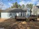 Rear of home with a spacious wooden deck, surrounded by mature trees and a serene backyard at 2260 Burdett Ridge Dr, South Fulton, GA 30349