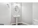 Cozy bathroom with stylish pedestal sink and modern vanity lighting at 6448 Mobilis Ct, Sugar Hill, GA 30518