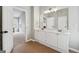 Bright bathroom featuring double vanity, tile floor, and open bedroom at 6448 Mobilis Ct, Sugar Hill, GA 30518