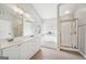 Bright bathroom featuring double vanity, soaking tub, and glass-enclosed shower at 6448 Mobilis Ct, Sugar Hill, GA 30518