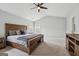 Spacious main bedroom featuring natural light, ceiling fan, and a rustic wood bedframe at 6448 Mobilis Ct, Sugar Hill, GA 30518