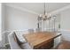 Dining room featuring an eye-catching chandelier, a rustic table, and decorative wall trim at 6448 Mobilis Ct, Sugar Hill, GA 30518