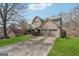 View of the front exterior with long driveway and well-manicured lawn at 6448 Mobilis Ct, Sugar Hill, GA 30518