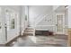 Bright foyer with wood-look floors and a staircase leading to the upper level at 6448 Mobilis Ct, Sugar Hill, GA 30518